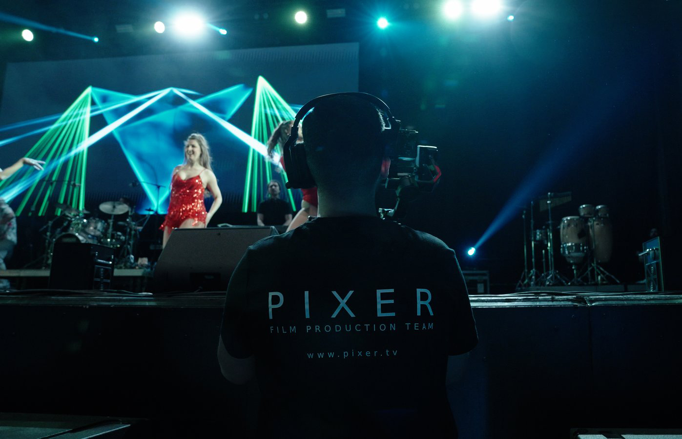 Pixer Filmproduktionsteam filmt ein Live-Konzert mit grüner geometrischer Lasershow auf der Bühne