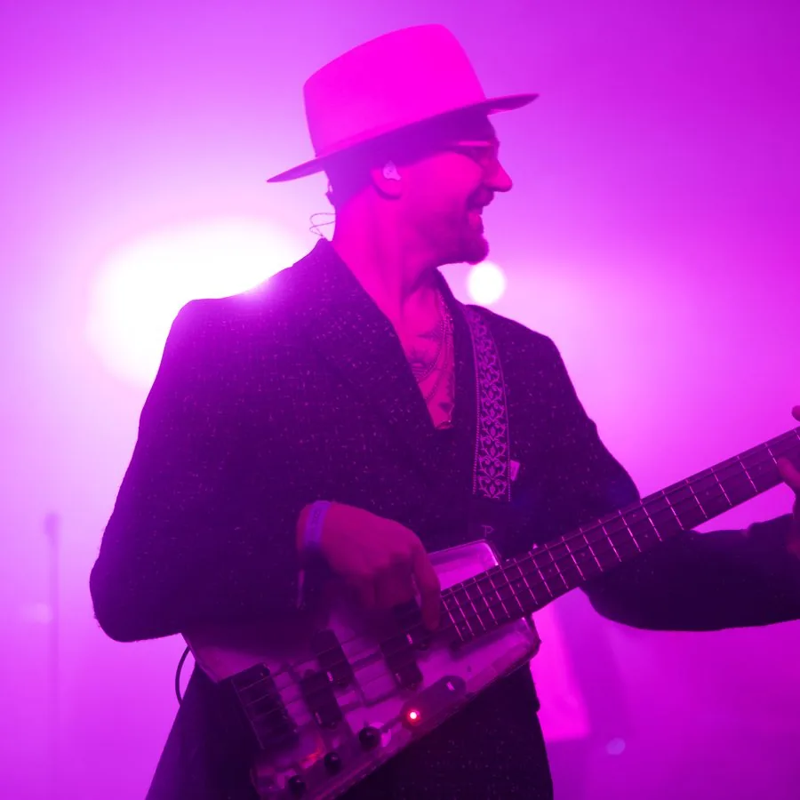 Gitarrist auf der Bühne mit pinkem und violettem Bühnenlicht, fotografiert von Pixer