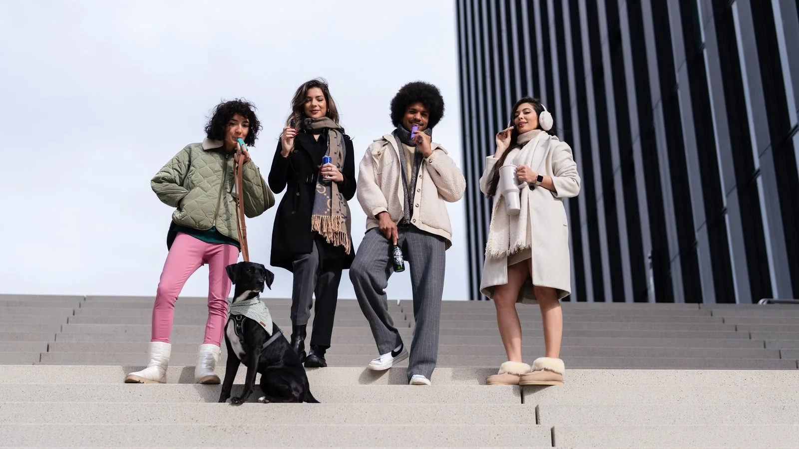Lifestyle-Gruppenfoto — vier Personen mit Hund auf einer Außentreppe, urbane Architektur, Produkt-Shooting von Pixer